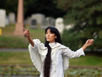 A human angel in Brooklyn's Green-Wood Cemetery gestures skyward at its annual Angels and Accordions Event