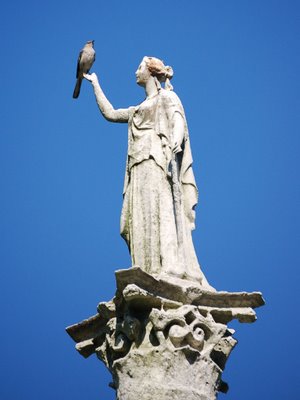 A beautiful figure at a pre-Civil War memorial supports a nightengale at Brooklyn's Greenwood Cemetery